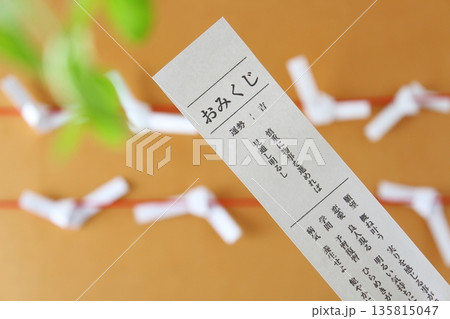 おみくじと結ばれたおみくじの和風背景素材 初詣・正月・運勢イメージ（横構図・コピースペース） 135815047