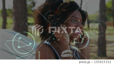 Smiling woman wearing headband standing in wooded clearing, with tent headphones holographic icons 135815152