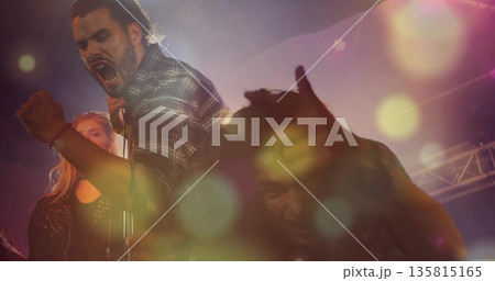 Singing lead vocalist wearing plaid flannel shirt energizing stage, with microphone and spotlights 135815165