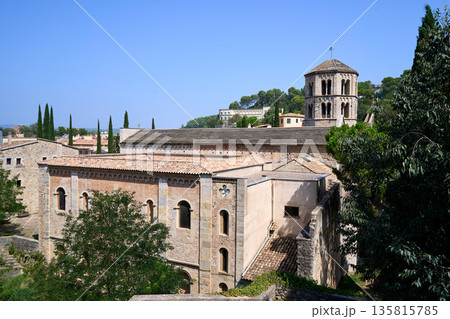 Peaceful Monastery Atop Lush Green Hills, Quiet Religious Site With Bell Tower Against Blue Sky Peaceful Monastery Atop Lush Green Hills, Quiet Religious Site With Bell Tower Against Blue Sky 135815785