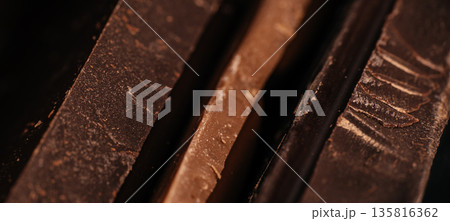 Dark chocolate macro texture with layered shards and rich cocoa surface Dark chocolate macro texture with layered shards and rich cocoa surface 135816362