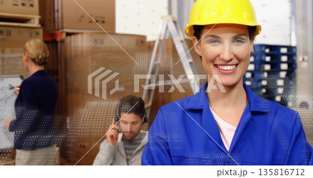Smiling technician wearing yellow hat and coveralls in warehouse, with cardboard boxes, copy space Smiling technician wearing yellow hat and coveralls in warehouse, with cardboard boxes, copy space 135816712