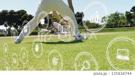 Diving keeper wearing white kit gloves and helmet catching cricket ball on grass with digital icons Diving keeper wearing white kit gloves and helmet catching cricket ball on grass with digital icons 135816744