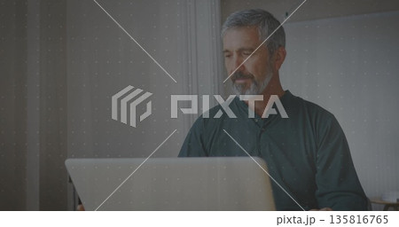 Typing mature adult male focusing on screen at home office, with silver laptop, copy space Typing mature adult male focusing on screen at home office, with silver laptop, copy space 135816765