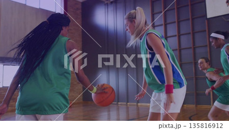 Dribbling Black athlete driving toward defender on gym court with green jerseys and bars copy space 135816912