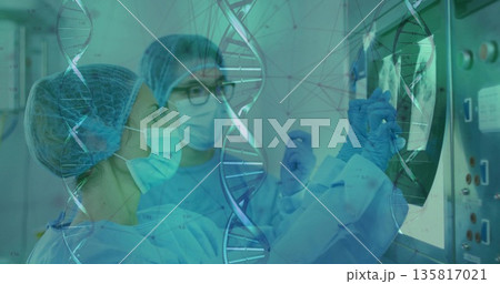Two surgeons examining medical monitor in operating room, with DNA helix overlay, control panel Two surgeons examining medical monitor in operating room, with DNA helix overlay, control panel 135817021