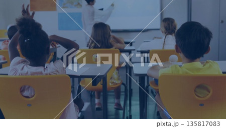 Pointing teacher writing on whiteboard map in classroom, with students at yellow desks Pointing teacher writing on whiteboard map in classroom, with students at yellow desks 135817083
