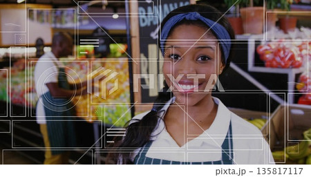 Smiling female employee in striped apron arranging produce at grocery store, with chalkboard sign Smiling female employee in striped apron arranging produce at grocery store, with chalkboard sign 135817117