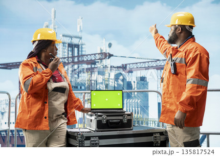 Green screen mockup laptop used by offshore platform crew using performance management program to reduce downtime. Colleagues use chroma key notebook integrating sensor readings to manage operations 135817524