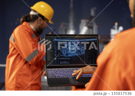 Close up of offshore platform technician using predictive AI models to forecast equipment maintenance needs. Specialist analyzing machine learning data on dashboard to prevent mechanical failures Close up of offshore platform technician using predictive AI models to forecast equipment maintenance needs. Specialist analyzing machine learning data on dashboard to prevent mechanical failures 135817536