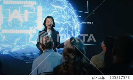 Asian public speaker makes artificial intelligence sales pitch with AI automation and big data analysis. Business forum presentation attracts investors, experts and diverse audience members. 135817578