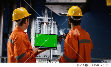 Green screen next to oil rig technicians analyze fuel extraction on industrial platform, petroleum production offshore while maintaining safe drilling operations. Marine ecosystem. 135817680