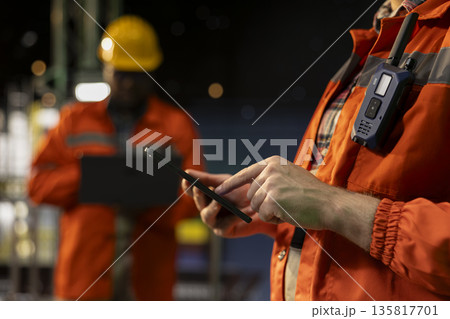 Close up of offshore platform specialist using tablet to analyze extraction efficiency during 24 hour operation. Drilling rig staff members checking vessel management systems with device late at night Close up of offshore platform specialist using tablet to analyze extraction efficiency during 24 hour operation. Drilling rig staff members checking vessel management systems with device late at night 135817701