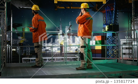 Worker communicates via radio stations on offshore oil platform under aurora borealis, managing drilling rig systems to reduce emissions and support maritime habitat extraction. 135817714