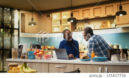 African american people preparing delicious breakfast and drinking coffee, following online recipe on laptop. Getting ready to eat toast slices and croissants, healthy food. African american people preparing delicious breakfast and drinking coffee, following online recipe on laptop. Getting ready to eat toast slices and croissants, healthy food. 135817738