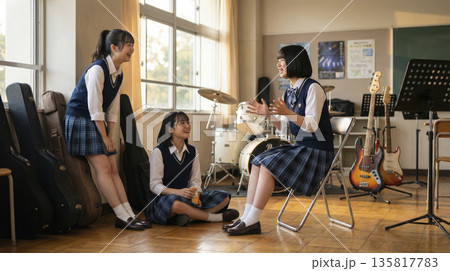 音楽室で楽器に囲まれて話す女子高校生たちの放課後 135817783