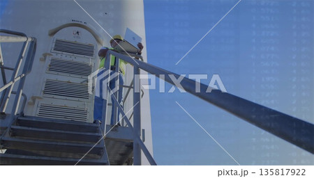 Holding open laptop, construction worker in hard hat comparing data on tower platform with railing Holding open laptop, construction worker in hard hat comparing data on tower platform with railing 135817922
