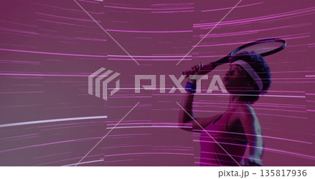 Holding racket overhead, athlete in pink top, white headband, blue wristband in studio, copy space Holding racket overhead, athlete in pink top, white headband, blue wristband in studio, copy space 135817936