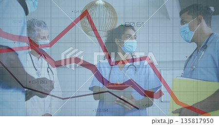 Discussing trends on line graph overlay in hospital corridor with clipboard tablet stethoscopes 135817950