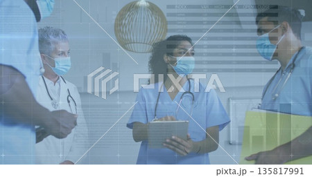 Holding clipboard nurse in scrubs masked briefing colleagues in hospital corridor, digital overlay Holding clipboard nurse in scrubs masked briefing colleagues in hospital corridor, digital overlay 135817991