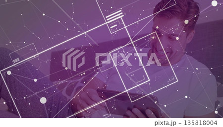 Navigating purple tinted interface, mid adult male using tablet sitting on sofa at home, copy space Navigating purple tinted interface, mid adult male using tablet sitting on sofa at home, copy space 135818004