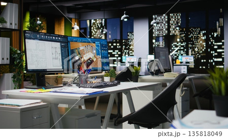 Contemporary office desk with CAD interface displaying digital blueprints and 3D renders of architectural projects. Ideal for architecture and construction professionals engaged in planning. 135818049