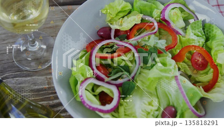 Showing salad bowl with lettuce, tomatoes, olives and basil on rustic table, with digital overlay 135818291