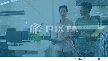 Two IT colleagues analyzing encryption code in modern office, with laptop and folder, copy space 135818363