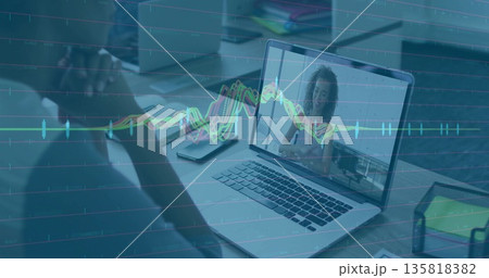 Sitting man facing laptop showing colleague chatting at office workspace with line graph overlay 135818382