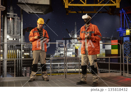 Black engineer with VR glasses on offshore oil platform uses virtual reality tech to simulate drilling operations and monitor machinery, ensuring safety protocols in petroleum extraction. 135818432