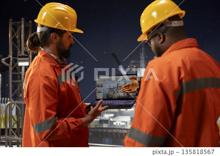 Drilling ship crew analyzing gear performance on laptop dashboard screen. Offshore platform coworkers brainstorming, monitoring oil extraction rates and system pressure using notebook 135818567