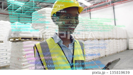 Warehouse inspector wearing safety vest scanning pallets with AR code overlay in aisle, with tablet Warehouse inspector wearing safety vest scanning pallets with AR code overlay in aisle, with tablet 135819639