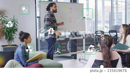 Presenting man pointing at whiteboard in meeting room, with floating energy icons and sticky notes 135819678