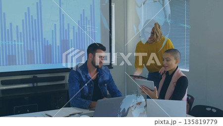 Collaborating professionals reviewing bar chart on screen in meeting room, with laptops and tablet Collaborating professionals reviewing bar chart on screen in meeting room, with laptops and tablet 135819779