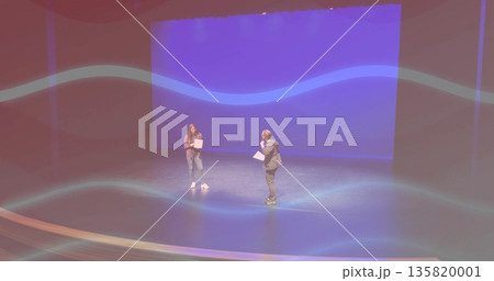 Rehearsing actors in plaid shirt and blazer reading scripts on stage, with lighting fixtures 135820001