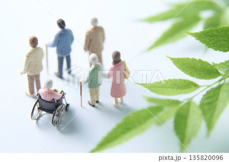 車椅子と家族と介護士の緑に包まれた穏やかな時間 135820096