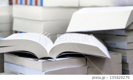 stack of books, close up. Open book on the table in library. Back to school concept. Open book on table with blur bookshelf background 135820270