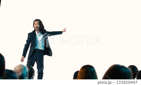 Asian product manager revealing new smartphone launch at convention event, showcasing smart interface with modern design. Engineer makes a sales pitch for product coming soon. 135820497