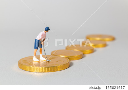 Miniature Golfer Standing on Stacked Gold Coins Miniature Golfer Standing on Stacked Gold Coins 135821617