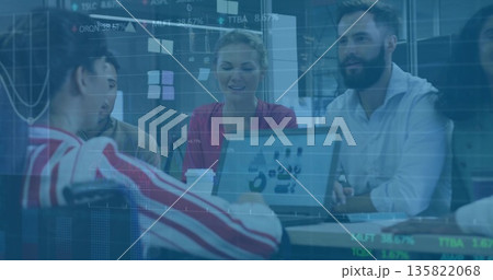 Reviewing team in business attire analyzing laptop charts at conference table, with sticky notes 135822068