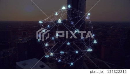 Hovering 3D network sphere glowing above cylindrical skyscraper at dusk, with social media icons 135822213