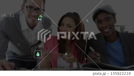 Examining jewelry pieces, coworkers in smart attire handling pendants in studio, with tweezers 135822219