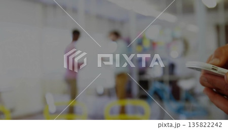 Holding white smartphone in right hand near coworkers discussing whiteboard in office, copy space 135822242