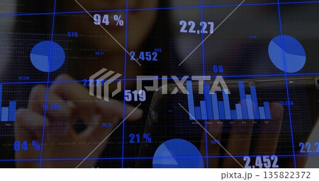 Interacting data analyst wearing jacket tapping touchscreen display in office, with floating charts 135822372