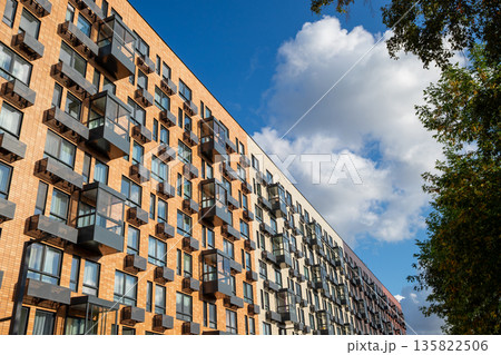 Modern residential building with many windows, air conditioner boxes. Urban architecture and real estate development. new multi-story residential building. Climate control system 135822506