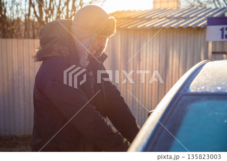 Man unlocking car door with a key. Person opening vehicle outside on a frosty sunny day. Driving car, going to work, taxi, delivery. Man unlocking car door with a key. Person opening vehicle outside on a frosty sunny day. Driving car, going to work, taxi, delivery. 135823003