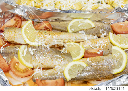 Prerape raw spiced hake for a bake in the oven with lemon, tomatoes, carrots, and onions in foil. Delicious fish for lunch or dinner, perfect for a diet. Tasty and fresh hake fish for bake with Prerape raw spiced hake for a bake in the oven with lemon, tomatoes, carrots, and onions in foil. Delicious fish for lunch or dinner, perfect for a diet. Tasty and fresh hake fish for bake with 135823141