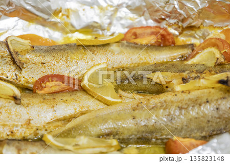 Spiced hake baked in the oven with lemon, tomatoes, carrots, and onions in foil. Delicious fish for lunch or dinner, perfect for a diet. Tasty hake fish baked with vegetables. Spiced hake baked in the oven with lemon, tomatoes, carrots, and onions in foil. Delicious fish for lunch or dinner, perfect for a diet. Tasty hake fish baked with vegetables. 135823148