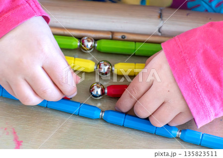 Child having fun with an authentic leisure activity, fine motor skills development 135823511