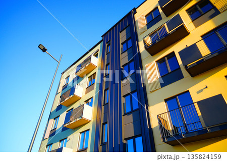 Facade building. Modern brick building with windows on blue sky and bright colors during day. Facade building. Modern brick building with windows on blue sky and bright colors during day. 135824159